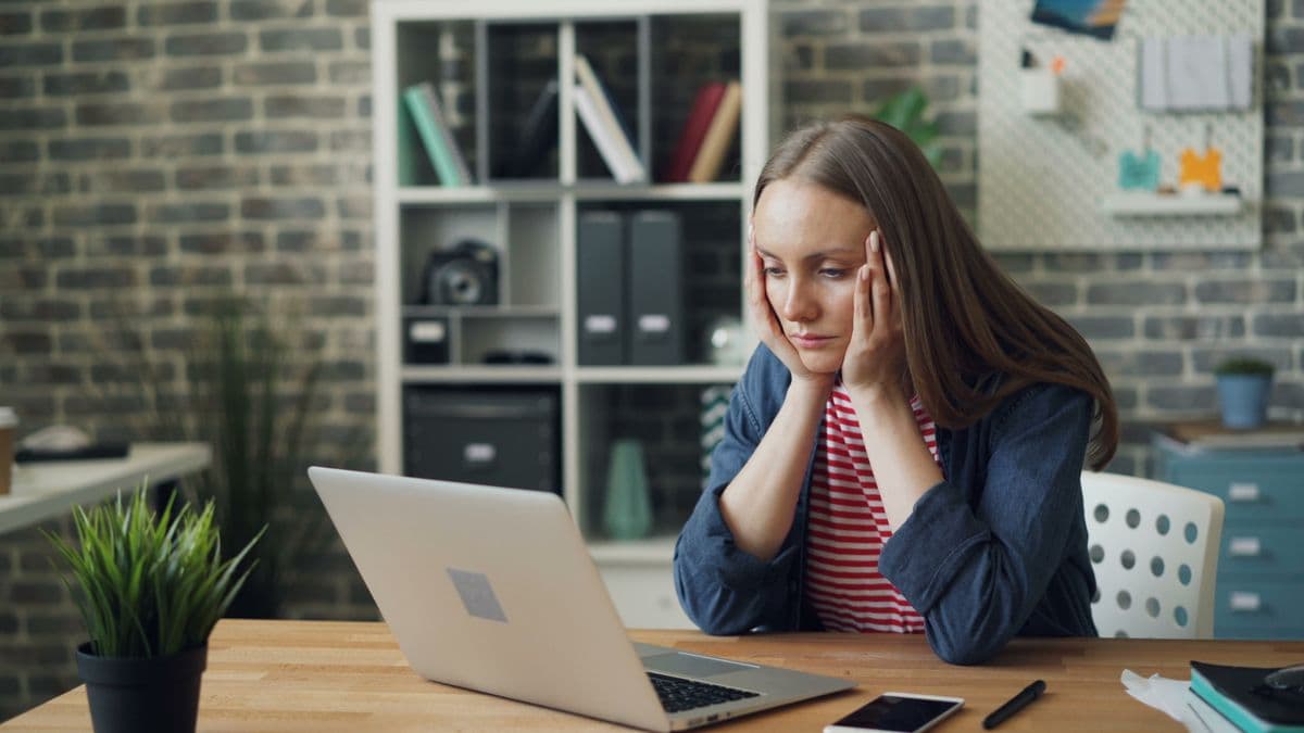 A person looking cautiously at a laptop while browsing listings