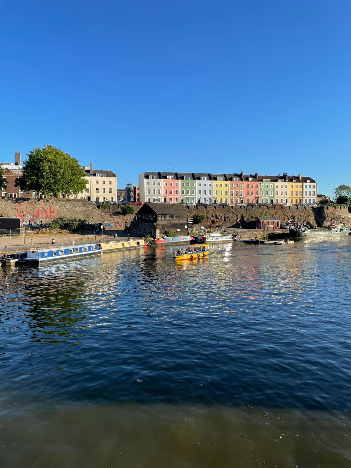 Colourful terraced houses above the Floating Harbour in Bristol, with narrowboats