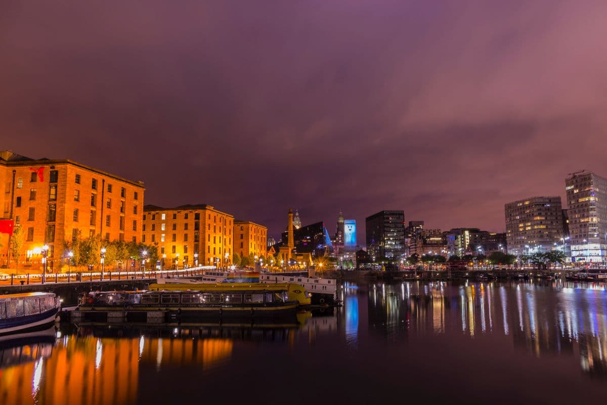 Liverpool's Albert Dock warehouses lit up at dusk over the water